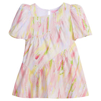 Girls/Tween woven dress in a bright pink/yellow/green watercolor print. Dress features a fun asymmetrical hem which adds a fun feature to the dress. Dress also has slight puff sleeves and also has a keyhole button closure on back of neckline.