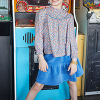 Our model can be seen wearing our awesome McCall Top in Devon Floral Blue which is paired easily with our Sally Skort in French Blue Corduroy--BISBY girl