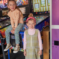 Girl on the right canoe seen wearing our Retro Jumper in Sage Tweed with our Pink Ribbed Turtleneck underneath. Our model on the left can be seen wearing our Sadie Top in Orange Sparkle Stripe paired with our Blue Floral Corduroy Twiggy Pants--BISBY Girl