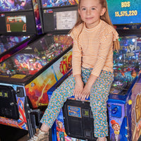 Our little model can be seen wearing our Twiggy Cords in Blue Floral Corduroy which match perfectly with our Orange Sparkle Stripe Sadie Top to complete the look--BISBY girl