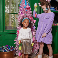 Model on the left can be seen wearing our Western Dress in Lilac Corduroy. Next to her our other model is seen in our Gold Lame Circle Skirt and paired with our Tory Top in Snow Pointelle to complete the look-BISBY girl