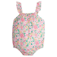 Baby girl woven bubble featured in a bright pink/yellow/green floral print. Bubble features ruffle straps and button closures along back and stride for easy put on access.