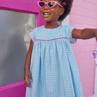 Girl dress with blue and pink floral print, with hot pink trim across bust and sleeves