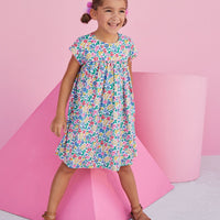 Girl wearing short sleeve dress for young girls with bright floral print.