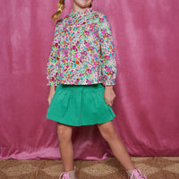 Girls/Tween skort in our Pine Green. Skort has built in shorts, elastic waistband, and is made of a lightweight corduroy fabric for a comfy feel. Pair it back with a long sleeve woven top in a magenta floral arrangement to complete the look.