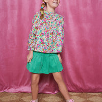 Girls/Tween skort in our Pine Green. Skort has built in shorts, elastic waistband, and is made of a lightweight corduroy fabric for a comfy feel. Pair it back with a long sleeve woven top in a magenta floral arrangement to complete the look.