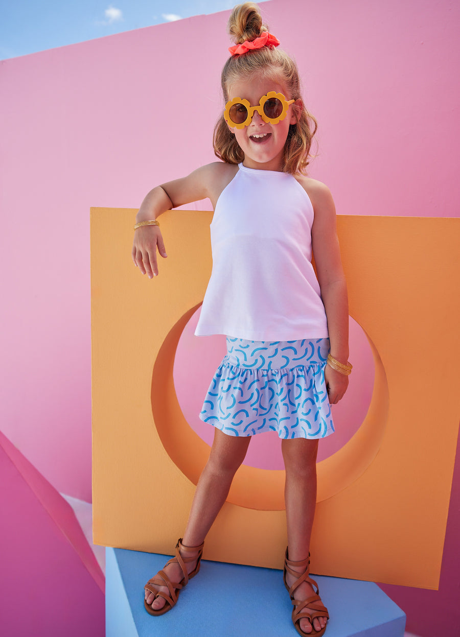 BISBY girl in our Sally Skort in our fun Blue Ripple pattern which has built in shorts and stretchy waistband. Pair it back with our halter top in white for a complete look.