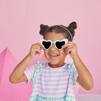 young girl wearing BISBY helen dress in pink and green stripe.