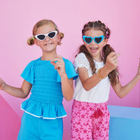 BISBY girl seen in our Richmond Shorts in our Pink Eyelet pattern. Hot pink eyelet embroidery on the shorts add an eye-catching aspect to the shorts which also have pockets and fixed tassle tie in the front of shorts. They also have an elastic waistband and are paired back perfectly with our contrast sleeve tee in our White Eyelet