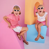 Hot pink ruched smocked top for girls and tweens with orange trim which pair perfectly back with our Richmond Shorts in our Flower Market Embroidery.