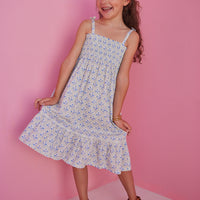 BISBY girl seen in our Lucy Dress in Vintage Azur which features a gorgeous yet simple blue and green floral pattern. This dress has fixed ties on the straps for an elevated look and ruching across the bust for a comfortable yet fitted look.