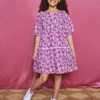 Girls/Tween woven dress which features a slight v-neck neckline, elbow length sleeves, and a pic rack detail along the bottom tier of dress. Print is made up of a magenta/pink/purple floral arrangement.