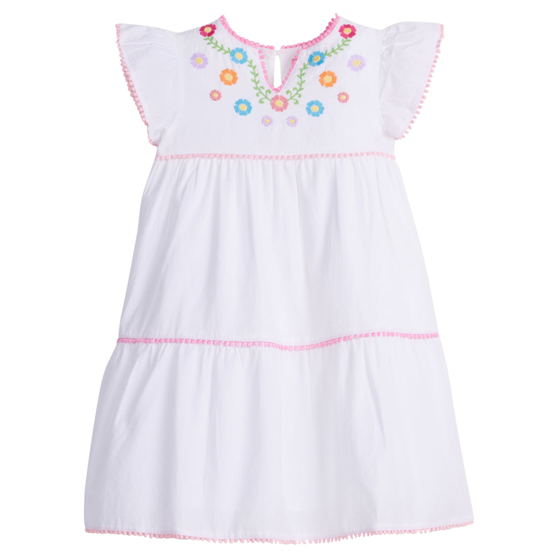 Girls/Tween woven white tiered dress with multi-color floral embroidery detail on chest/along the v-neck neckline. Dress also features light pink pom poms along sleeve and first and bottom tiers of dress. A row of bubblegum pink pom poms is seen along the second tier of dress and around neckline. There is also a button closure at back of neckline for a secure fit.