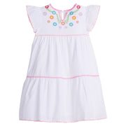 Girls/Tween woven white tiered dress with multi-color floral embroidery detail on chest/along the v-neck neckline. Dress also features light pink pom poms along sleeve and first and bottom tiers of dress. A row of bubblegum pink pom poms is seen along the second tier of dress and around neckline. There is also a button closure at back of neckline for a secure fit.