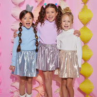 Models can be seen in our circle shorts in an ice blue, purple, and gold metallic colors. Each skort has built in shorts for a secure fit and all have matching ribbed turtlenecks paired back with them.