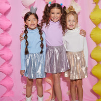 Models can be seen in our circle shorts in an ice blue, purple, and gold metallic colors. Each skort has built in shorts for a secure fit and all have matching ribbed turtlenecks paired back with them.