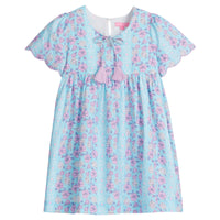 Girls/Tween woven dress in aqua/purple/white floral pattern. Dress features a slight v-neckline, tie tassel at neckline with lilac tassels, and scallops at end of sleeves to complete the look. There is also a button closure at back for a relaxed but secure fit.