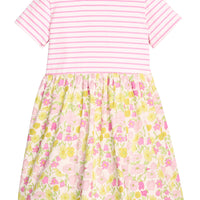 BISBY girl dress in half knit fabric and half woven fabric. The top of the dress is a knit pink and white fabric and the bottom of the dress is a woven pink and yellow floral fabric. Dress features button closure at back as well for a secure but comfy fit.