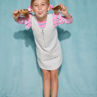 Girls/Tween knit top in our bubblegum stripe. Top features a pink/blue/yellow stripe color way and is made of a super soft knit material. Also has ruffle angle sleeve feature at the top of the sleeves. Model can be seen wearing top underneath a gray quilted jumper to complete the look.