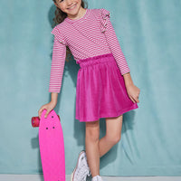 Girls/Tween velour skirt in a magenta color. Skirt features an elastic waistband and pockets at the front, and is made of a super soft/stretchy velour material. Pair it back with a knit long sleeve top with angel sleeves in a magenta and metallic sparkle stripe top.