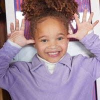 Little girl can be seen wearing our Lilac Polo pullover layered with our Cream colored essential turtleneck underneath--BISBY girl