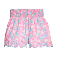 BISBY girl woven white shorts with a pink/blue/white floral print. Shorts feature a smocked waistband, pockets, and a scallop bottom hem for an elevated look.