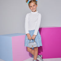 Girls/Tween skort in our Roland Floral Blue floral pattern which features white flowers on a blue background. Skort featues an elastic waistband and built in shorts for a comfy relaxed fit. Pair it back with our long sleeve white knit top with a ruffle neckline to complete the look.