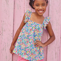 Little girl wearing ruffle adjustable strap top which features a square neckline and a colorful floral print.