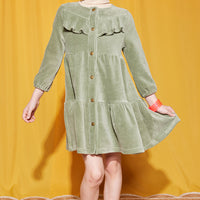 Little girl can be seen wearing our Sage Green Corduroy Western styled dress paired with our essential Tan turtleneck underneath--BISBY girls