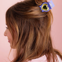 Woman with a hair heart hair clip on a pink background