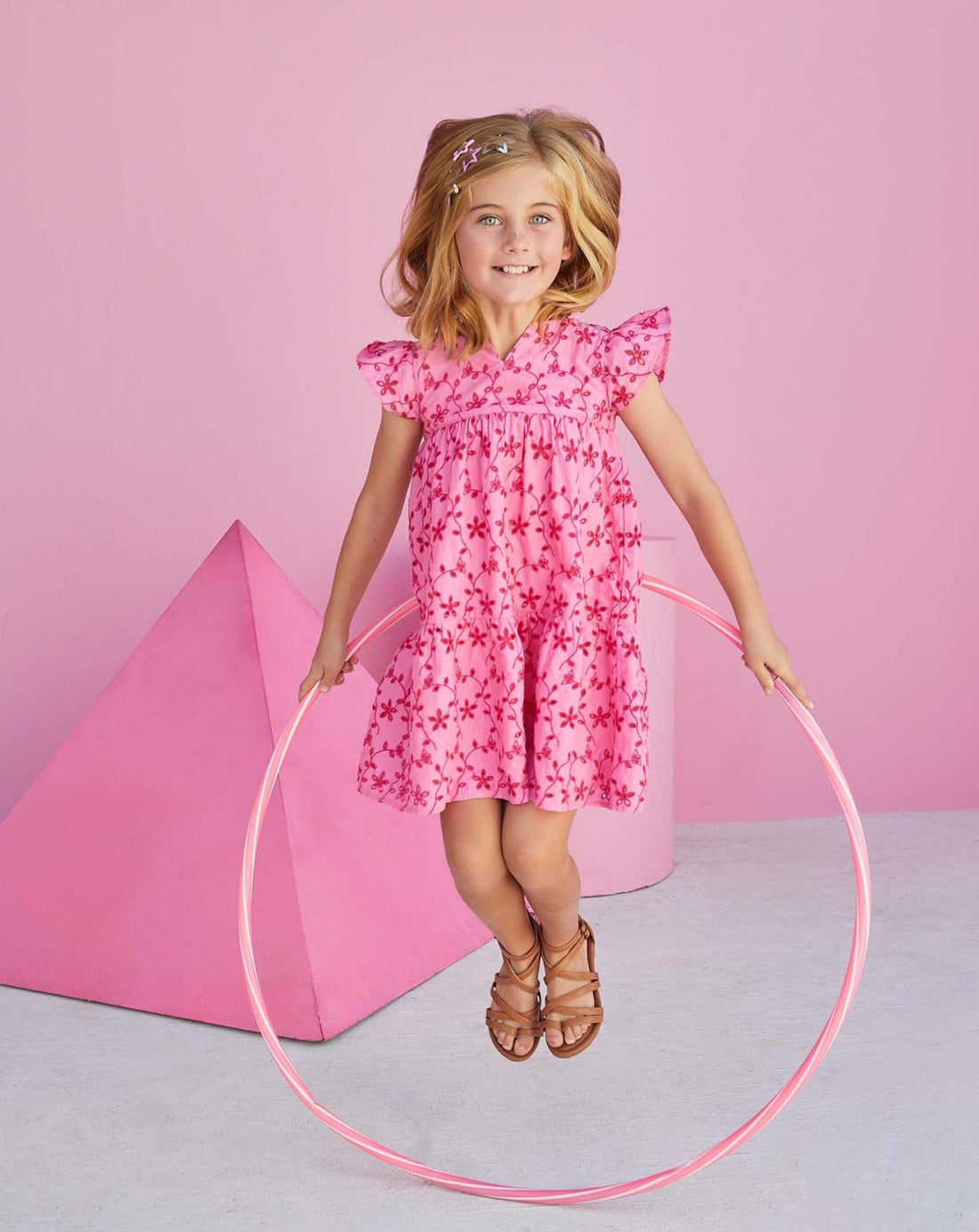 Young girl wearing pink eyelet dress from BISBY.