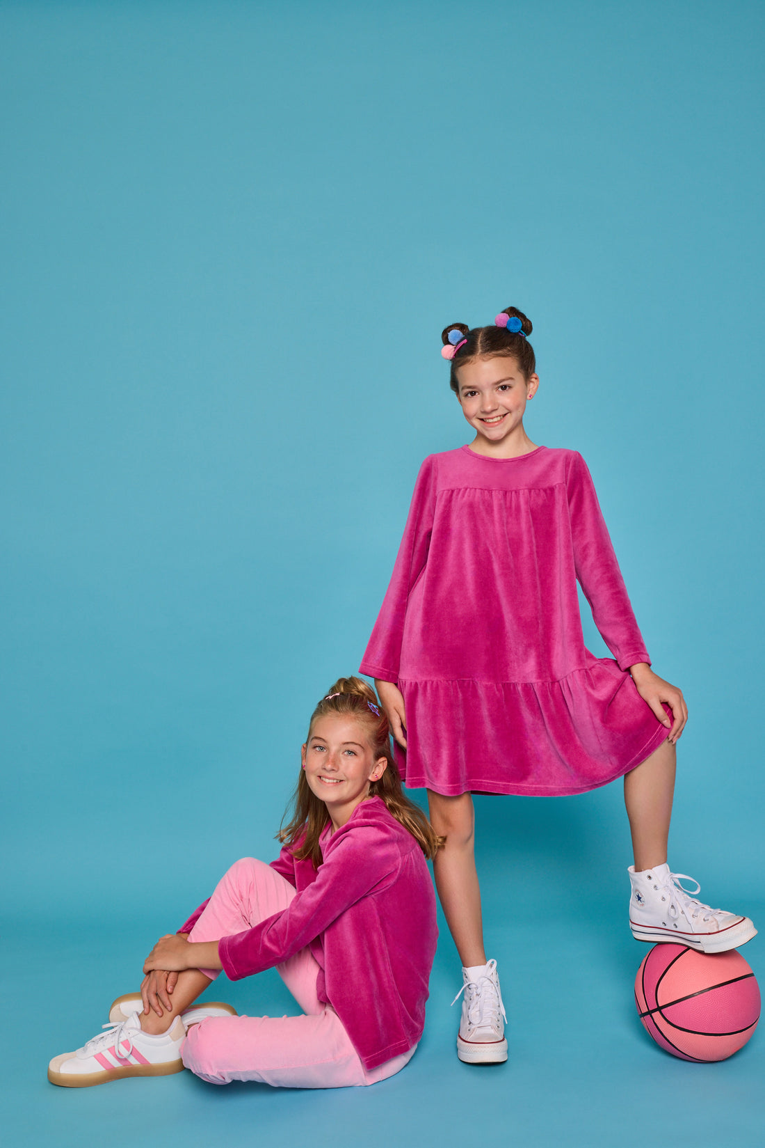 Model can be seen wearing long sleeve velour magenta top paired back with a pair of bubblegum pink corduroy pants. Top features button closure at back and pants have pockets as well. Coordinating back as well with our long sleeve magenta velour dress. 