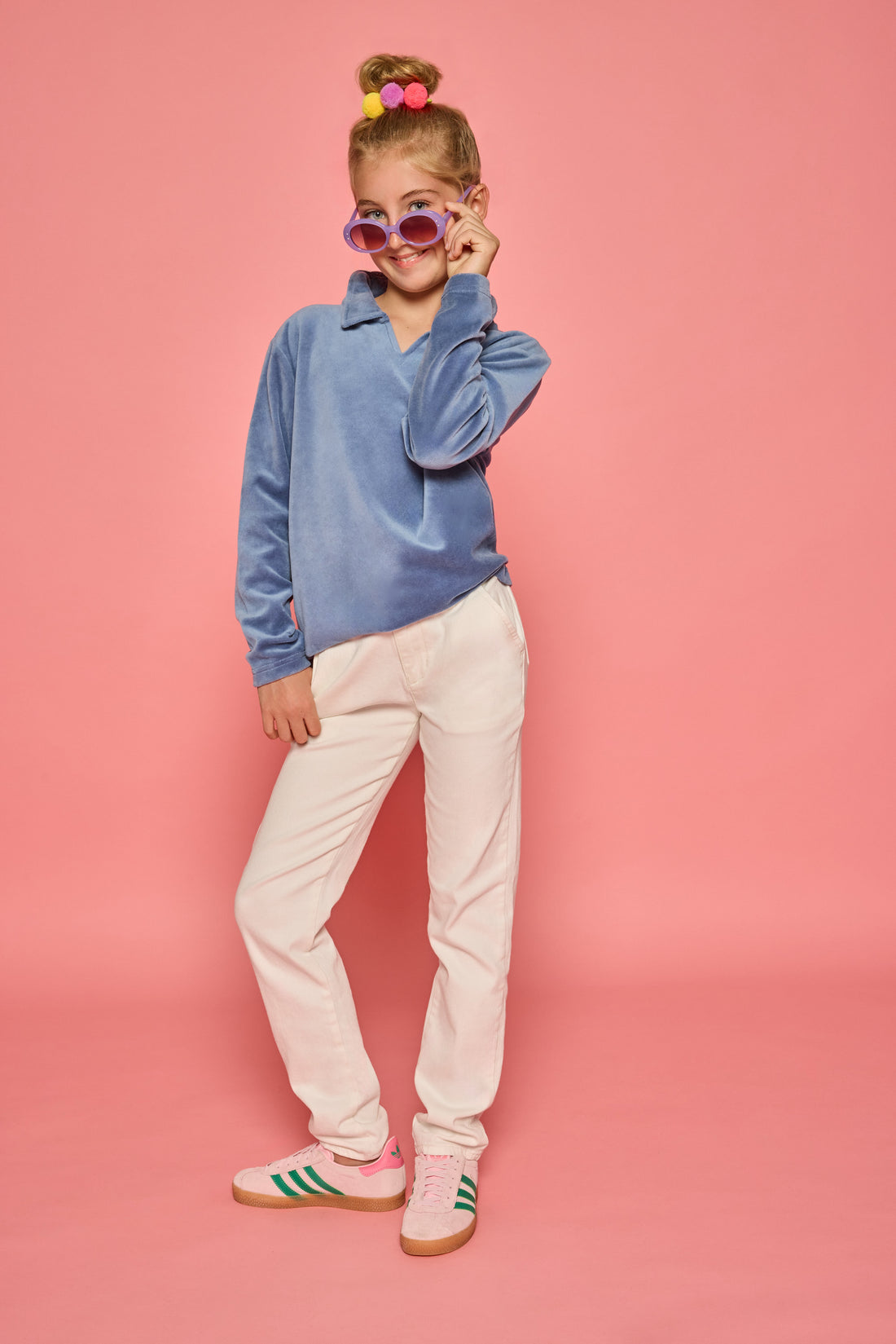 Model can be seen wearing a dusty blue velour pullover that features a fold over collar for easy over the head access. Paired back with basic white denim jeans to complete the look. 
