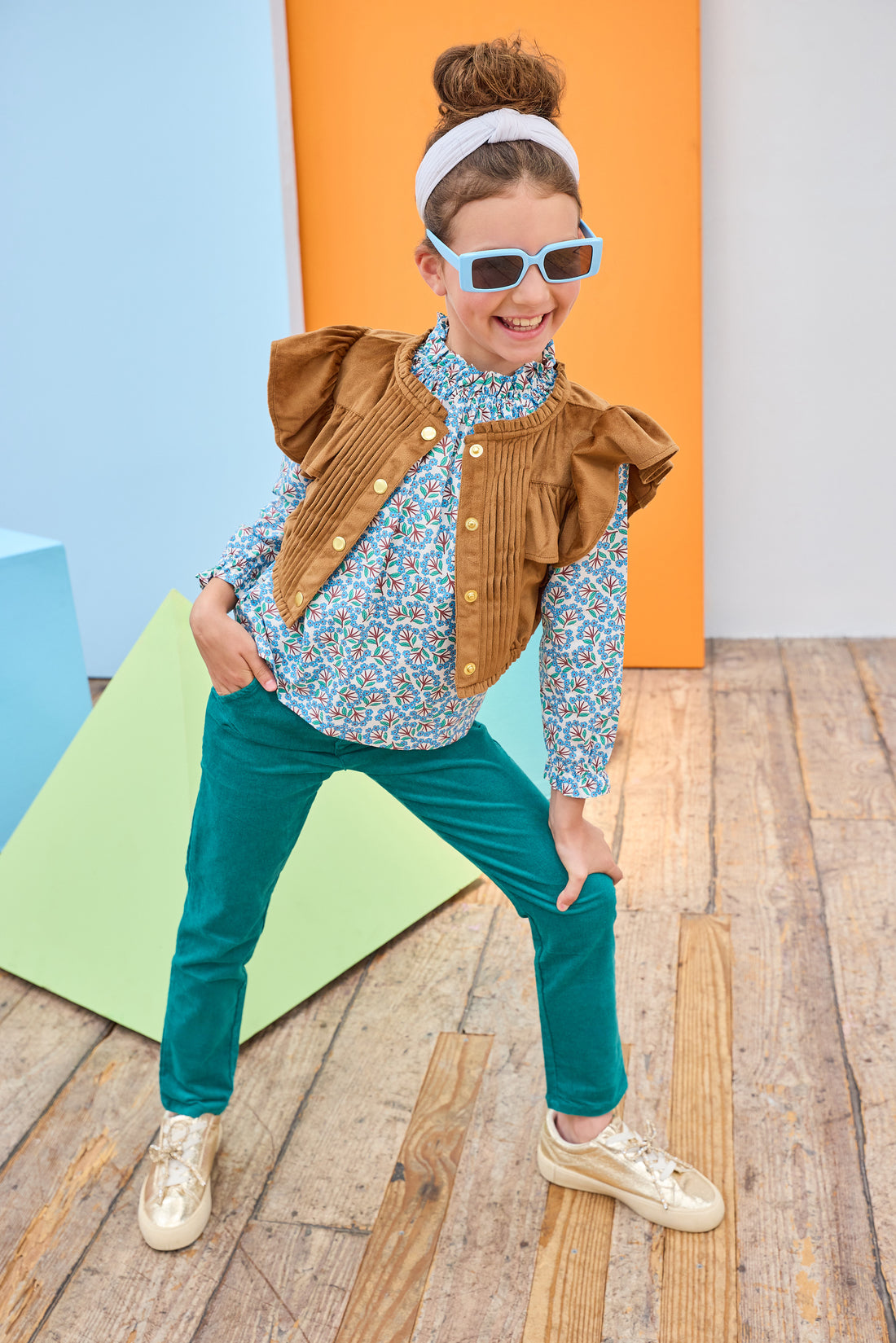 Tween model can be seen wearing a brown suede top, featuring button closures, so it can be worn as a cape/layering piece or as a shirt on its own. Paired back with our brown and green floral and velvet pants to complete the look. 
