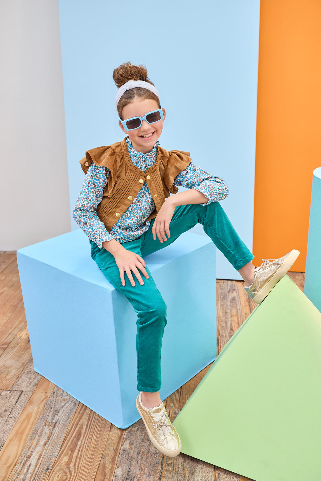 Tween model can be seen wearing a brown suede top, featuring button closures, so it can be worn as a cape/layering piece or as a shirt on its own. Paired back with our brown and green floral and velvet pants to complete the look. 