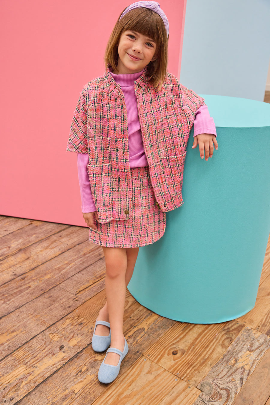 Model can be seen wearing tweed skort in magenta/pink/green plaid pattern paired back perfectly with the cape in the matching print and material. 