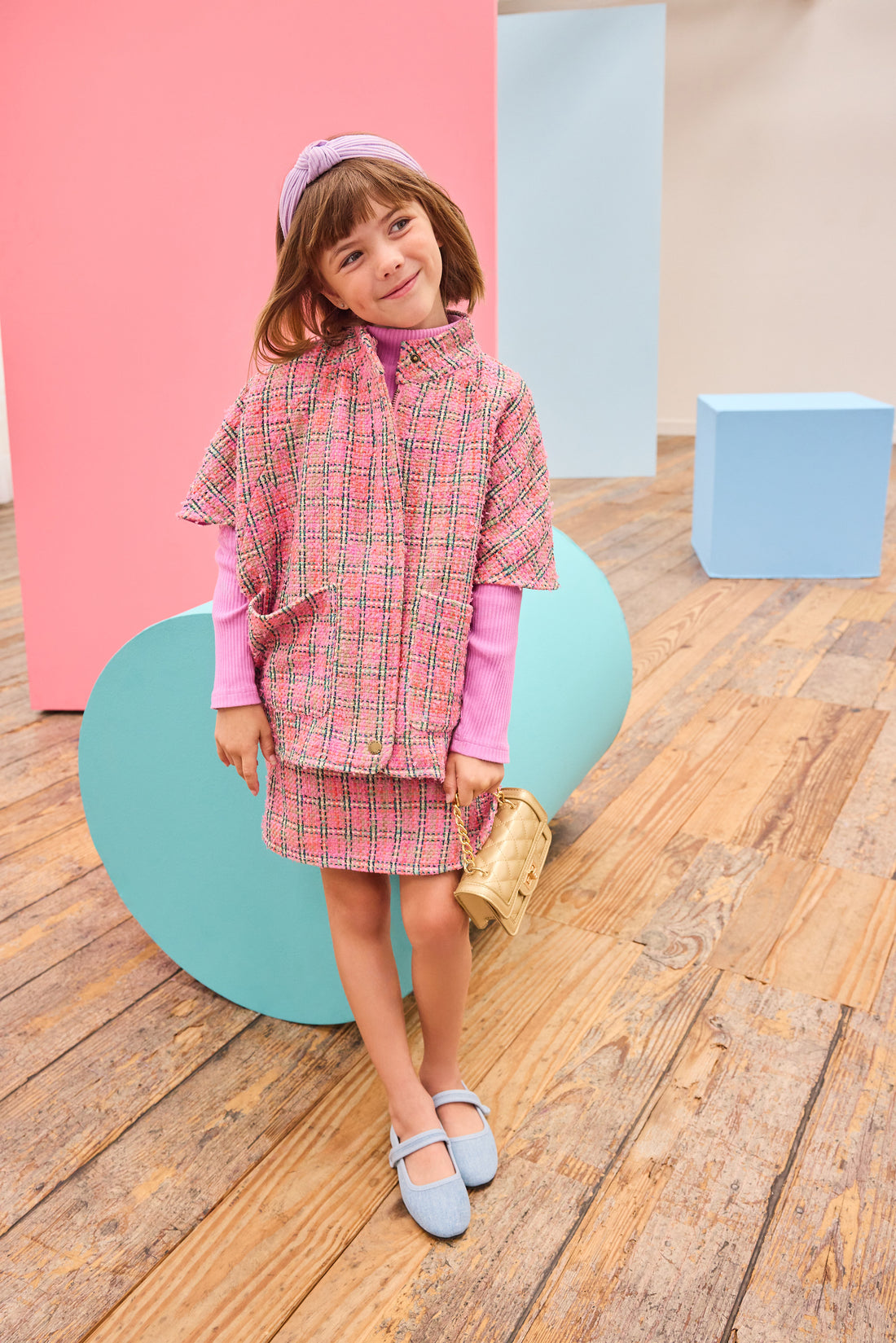 Model can be seen wearing tweed skort in magenta/pink/green plaid pattern paired back perfectly with the cape in the matching print and material. 