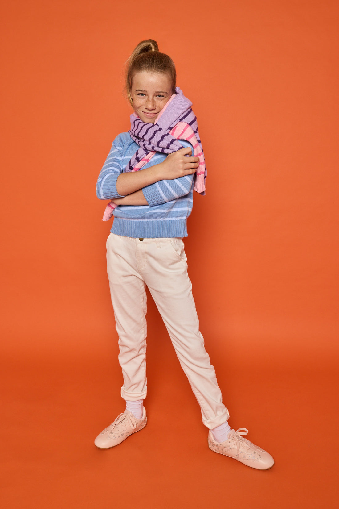 Model can be seen wearing our knit blue and light blue stripe sweater paired back with white jeans to complete the look. Model also has our other sweaters in purple/dark purple stripe and pink/hot pink stripe for a fun and fresh look. 