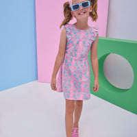 Model can be seen wearing a woven pink/light blue floral dress that features two cutout features on the sides of the dress to give it an elevated/big girl feel. 
