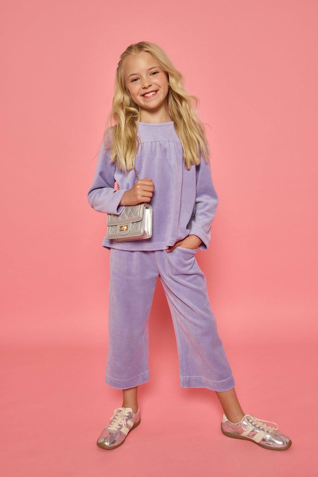 Model can be seen wearing a matching lavender velour set. Long sleeve top features button closure at back and pants feature pockets and an elastic waistband for a relaxed but secure fit.