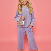 Model can be seen wearing a matching lavender velour set. Long sleeve top features button closure at back and pants feature pockets and an elastic waistband for a relaxed but secure fit.