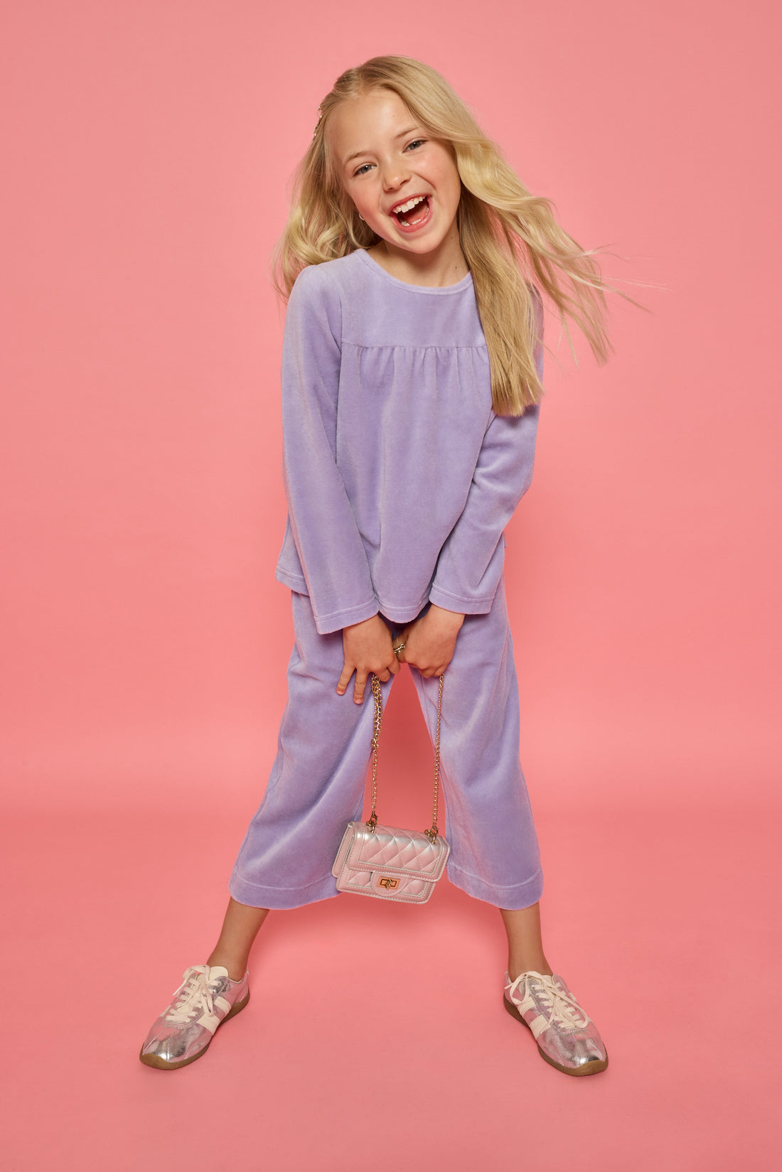 Model can be seen wearing a matching lavender velour set. Long sleeve top features button closure at back and pants feature pockets and an elastic waistband for a relaxed but secure fit.