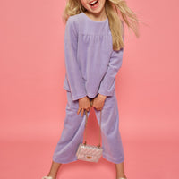 Model can be seen wearing a matching lavender velour set. Long sleeve top features button closure at back and pants feature pockets and an elastic waistband for a relaxed but secure fit.