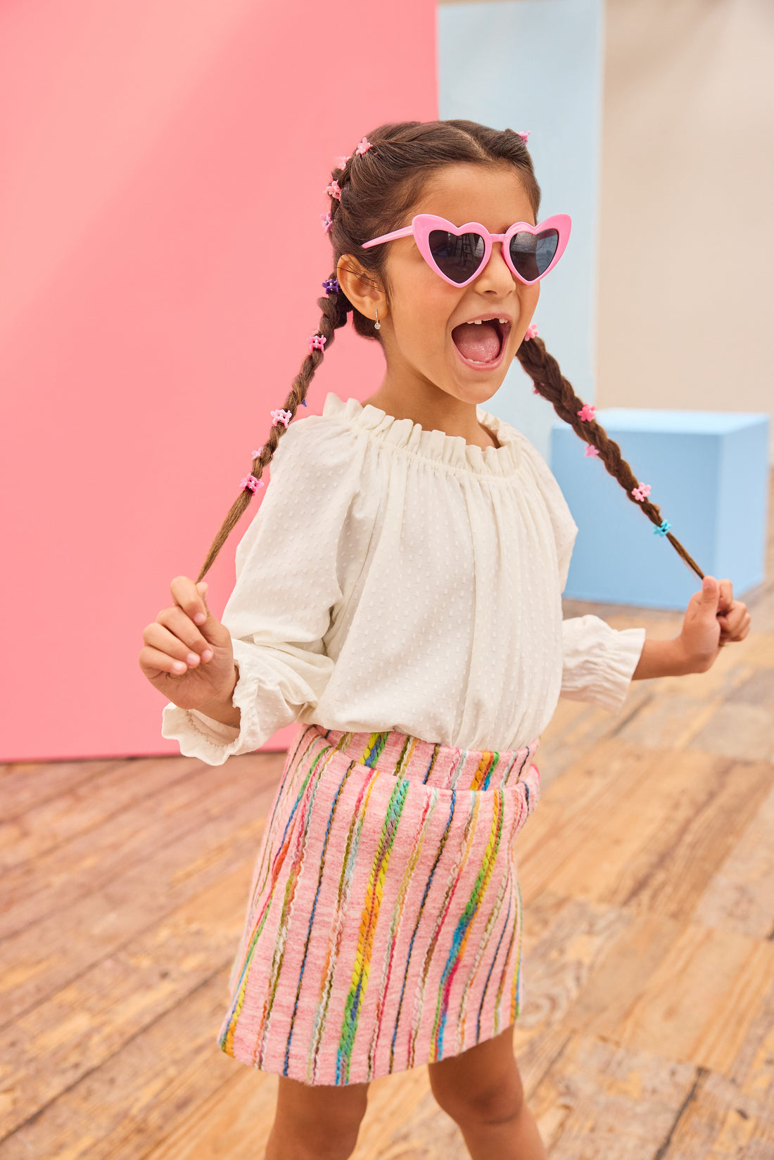 Model can be seen wearing a white pointelle knit top paired back with a skort in multi-color wool. Skort features an elastic waistband and built in shorts for a secure but comfy fit.