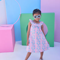 Model can be seen wearing a blue and pink floral woven dress that features an elastic scallop neckline detail to elevate the look.