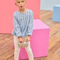 Model can be seen wearing a light blue shirt that features white dobby detailing and white lace stripes which pairs back perfectly with ivory jeans to complete the look. 