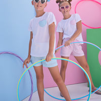 Model in front can be seen wearing a white knit tee that features a heart faux pocket in a sparkly blue seersucker fabric that pairs back perfectly with the matching shorts in the same fabric to complete the look. 
