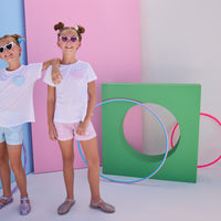 Model on left can be seen wearing woven seersucker sparkly blue shorts that feature two pockets in front and an elastic waistband. Shorts pair back perfectly with matching white tee that has the same sparkly blue seersucker fabric on the faux heart pocket to complete the look.