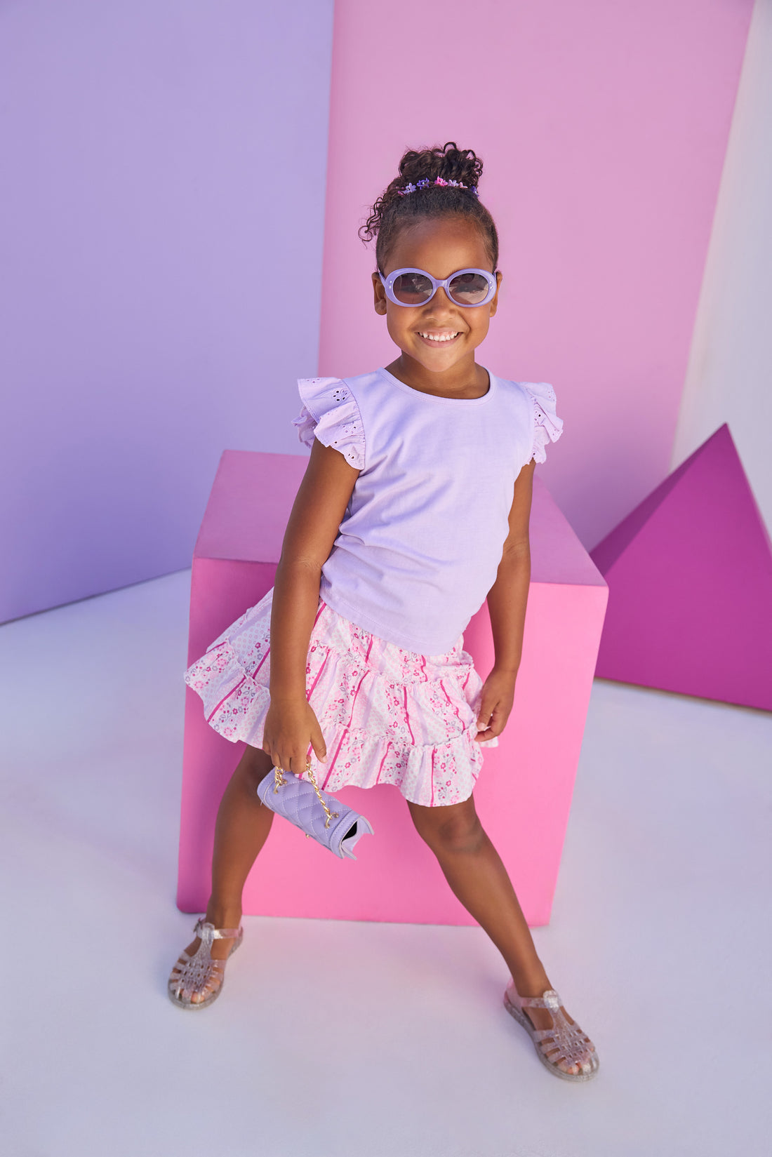 Model can be seen wearing lilac knit tee shirt that features an eyelet detail on the angel sleeve for an elevated look. Top pairs back perfectly with lilac/pink/white floral print skort. Skort features two tier detail, built in shorts, and elastic waistband for a secure but comfy fit. 
