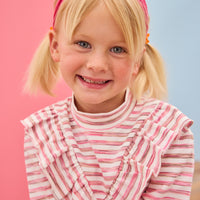 Model can be seen wearing a knit long sleeve stripe  top that features a v-ruffle detail down the center of the shirt for an elevated look. 